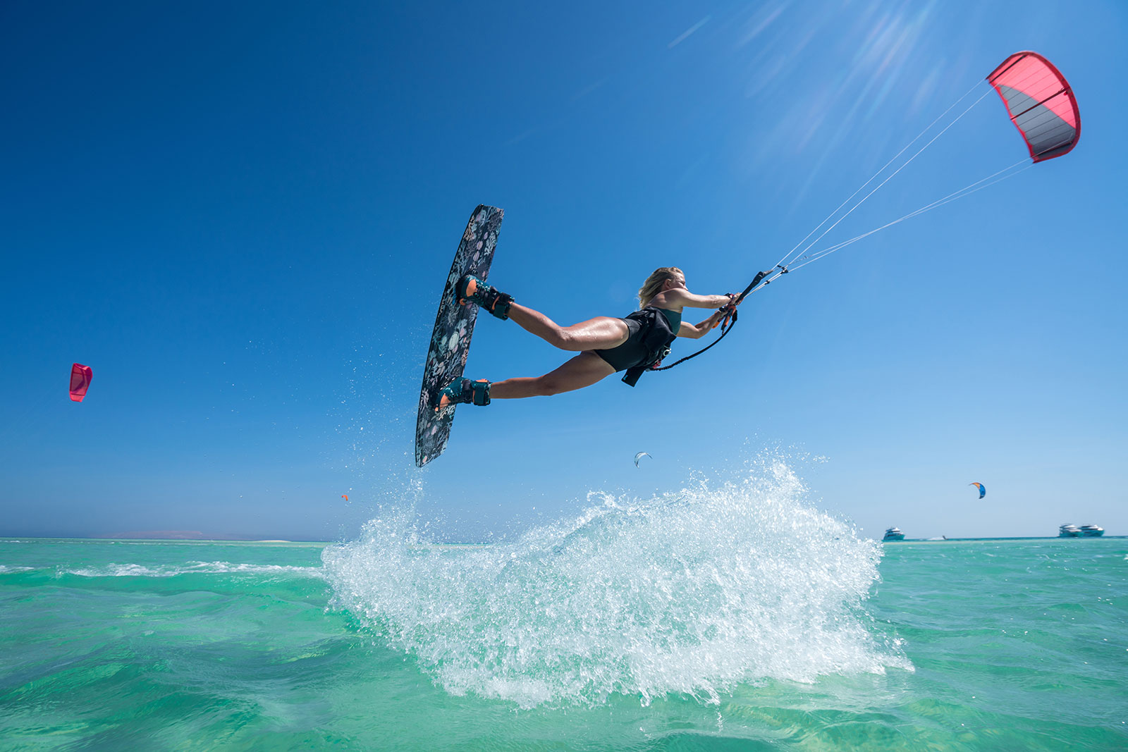Indigo-House_exuma-11_1600 Woman kiteboarding over turquoise water under a bright blue sky in Exuma.