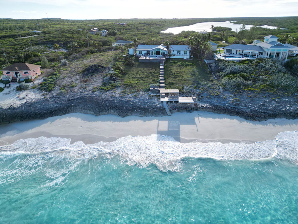 Aerial shot of Indigo House Exuma with a private boardwalk leading from the villa to the beach and ocean.