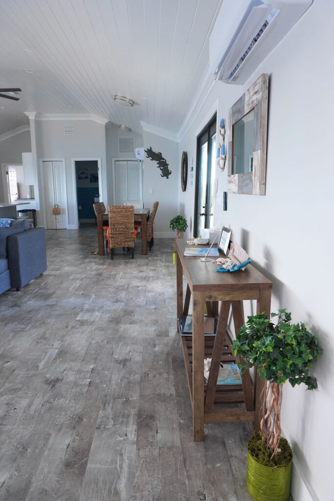 Dining area and hallway view at Indigo House Exuma featuring light wood flooring and wall decor.
