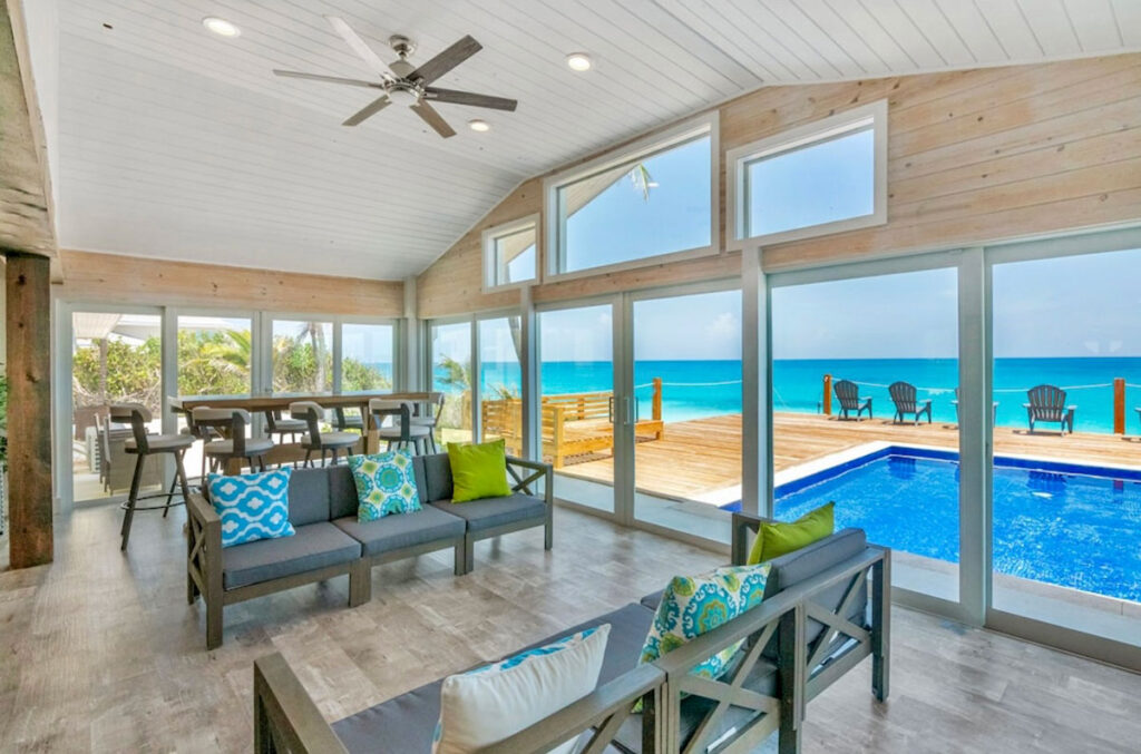 Open living room at Indigo House Exuma overlooking the private pool and ocean beyond.
