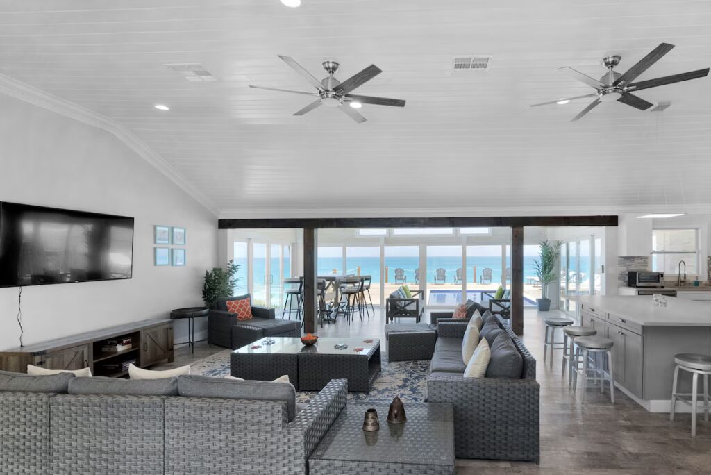 Indoor lounge space at Indigo House Exuma with sliding doors to the deck and comfortable seating.